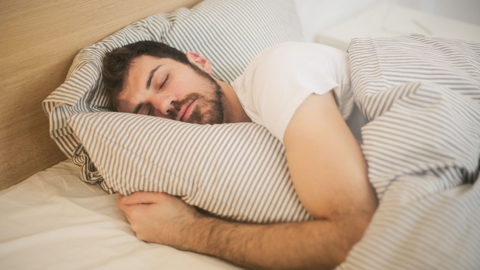 Pessoa dormindo na cama, de lado