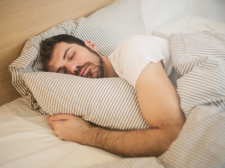 Pessoa dormindo na cama, de lado